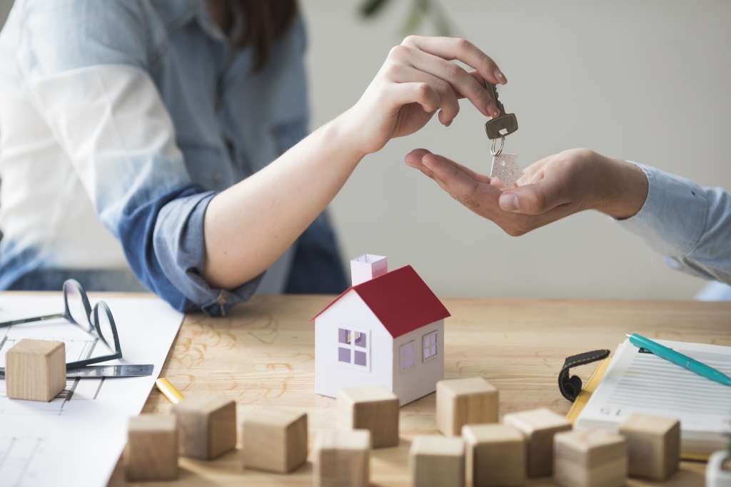 close-up-woman-s-hand-giving-house-key-man-wooden-table.jpg ключи